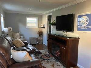 a living room with a couch and a flat screen tv at Quaint Cottage - Kansas City Area in Kansas City