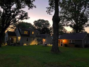 a house with a tree in a yard at night at Quaint Cottage - Kansas City Area in Kansas City