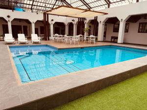 a large swimming pool with chairs and a table at Hotel Ramada in Guayaquil