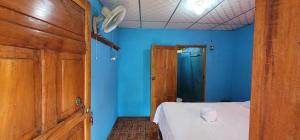 MéridaにあるMonkey's Island Hostelの青い壁の客室で、ベッド1台が備わります。