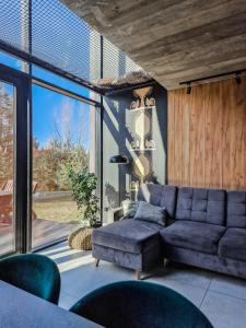 a living room with a blue couch and chairs at Ostoja Narwiańska - sauna & forest retreat in Nagórki +24 photos