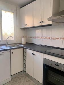 a kitchen with white cabinets and a sink and a window at Cabo Cervera Sea View in Torrevieja +4 photos