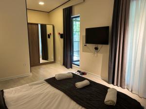 a bedroom with a bed with two pillows and a television at Xalxal Balayi Hotel in Xalxal