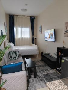 ein Wohnzimmer mit einer Couch und einem Bett in der Unterkunft Rare find Dubai in Dubai