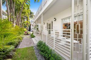 Una vista exterior de una casa blanca con árboles y plantas. en Lux Designer Apt 2BR and 2BA in Heart of Miami Beach, en Miami Beach