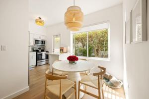 a kitchen and dining room with a white table and chairs at Lux Designer Apt 2BR and 2BA in the Heart of MIA Beach in Miami Beach