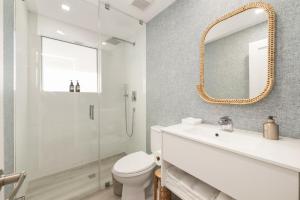 a bathroom with a toilet and a sink and a mirror at Lux Designer Apt 2BR and 2BA in the Heart of MIA Beach in Miami Beach