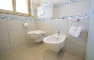 a bathroom with a toilet and a sink at Casa Verde Mare in La Caletta