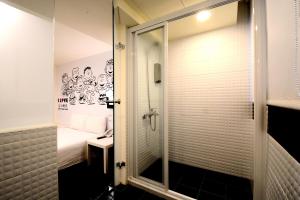 ein Bad mit einer Dusche und einer Glastür in der Unterkunft Sleep Taipei in Taipeh