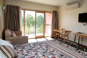 a bedroom with a bed and a table and a desk at Forbes Victoria Inn in Forbes
