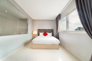 a bedroom with a bed with a red pillow at Collection O Sunshine Garden Hotel - Near SECC in Ho Chi Minh City +30 photos