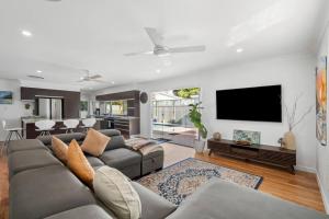 un salon avec un canapé et une télévision à écran plat dans l'établissement Bels Florida Family Getaway - Pool, WiFi, BBQ, à Gold Coast
