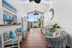 un porche couvert avec des canapés et des chaises sur une maison dans l'établissement Bels Florida Family Getaway - Pool, WiFi, BBQ, à Gold Coast