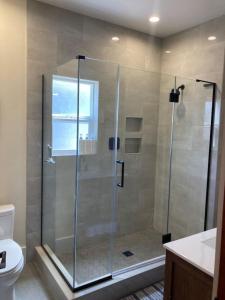 a shower with a glass door in a bathroom at Henderson Hideout Hot Tub and Pet Friendly. in Eureka