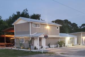 a white house with a sign on the side of it at TigerMinnow Coles Lodge in Carrabelle