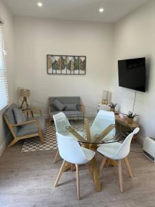 a living room with a table and chairs and a tv at Beautiful comfortable cottage in Orange