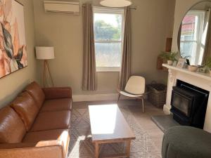 a living room with a couch and a fireplace at Beautiful comfortable cottage in Orange