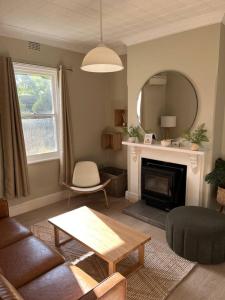 a living room with a couch and a table and a mirror at Beautiful comfortable cottage in Orange