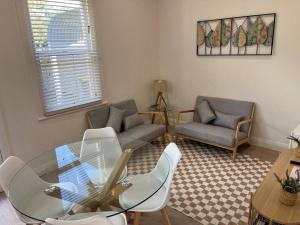 a living room with a glass table and chairs at Beautiful comfortable cottage in Orange