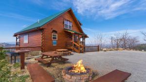 a log cabin with a fire pit in front of it at Wild Honey in Sevierville