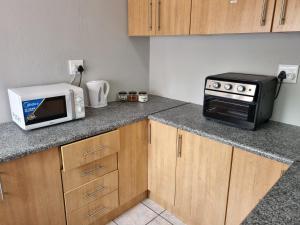 a kitchen with a microwave and a toaster oven at Daai Plek Akkommodasie in Sasolburg