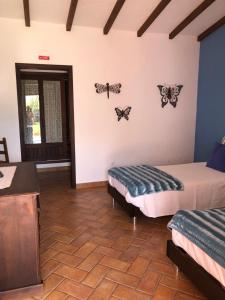 a room with two beds and butterflies on the wall at Monte Novo da Longueira Turismo Rural in Longueira +50 photos
