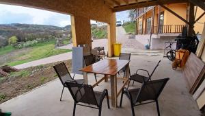 a table and chairs on a patio with a view at Cabana Ene Strada Poienari nr 13 A in Râmnicu Vâlcea