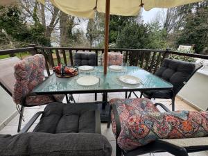 a table with chairs and an umbrella on a balcony at The Big apartment Papa Nero Pelion in Agios Ioannis Pelio