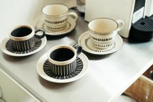 four cups of coffee on plates on a counter at Karuizawa Mori Shiki VILLA - Vacation STAY 57078v in Kutsukake +23 photos