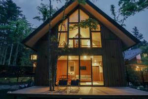 a frame house with glass windows and a patio at Karuizawa Mori Shiki VILLA - Vacation STAY 57078v in Kutsukake