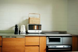 a kitchen with a counter with a toaster oven and a microwave at Karuizawa Mori Shiki VILLA - Vacation STAY 57077v in Kutsukake