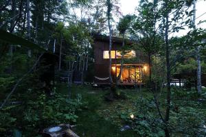 a cabin in the woods with lights in the trees at Karuizawa Mori Shiki VILLA - Vacation STAY 57077v in Kutsukake