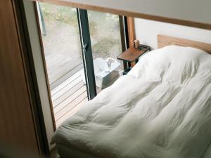 a bedroom with a bed and a large window at Karuizawa Mori Shiki VILLA - Vacation STAY 57076v in Kutsukake