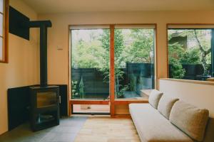 a living room with a couch and a wood stove at Karuizawa Mori Shiki VILLA - Vacation STAY 57075v in Kutsukake