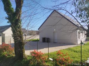 a white building with a tree in the yard at Domaine de Veauce proche de Bourges in Saint-Doulchard