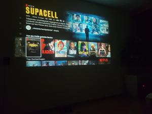 a television screen with a bunch of movies on it at 10 Min zur Altstadt, Scheunen Ferienwohnung, Sternenhimmel im Wintergarten mit Grill, Lift und Kino in Trier +23 photos