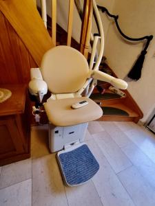 a chair sitting under the stairs in a room at 10 Min zur Altstadt, Scheunen Ferienwohnung, Sternenhimmel im Wintergarten mit Grill, Lift und Kino in Trier