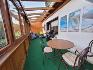 a room with a table and chairs and a couch at 10 Min zur Altstadt, Scheunen Ferienwohnung, Sternenhimmel im Wintergarten mit Grill, Lift und Kino in Trier