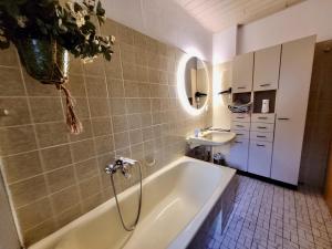 a bathroom with a tub and a sink at 10 Min zur Altstadt, Scheunen Ferienwohnung, Sternenhimmel im Wintergarten mit Grill, Lift und Kino in Trier