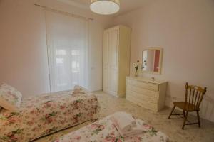 sypialnia z 2 łóżkami, komodą i lustrem w obiekcie Casa Vacanze Anna & Giulia w mieście Torchiara