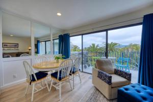 a dining room with a table and chairs and a balcony at 217W 217 Whittley Ave in Avalon