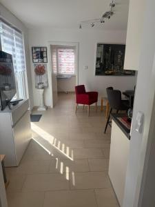 a kitchen and living room with a red chair at Gästewohnung Scharfe Lanke in Berlin +6 photos