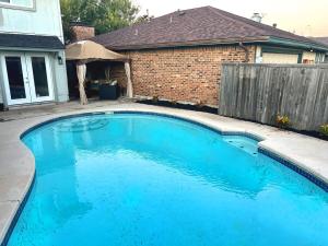 a large blue swimming pool in a yard at Luxury Home w Pool, Open Kitchen, Poker Room & More in Dallas