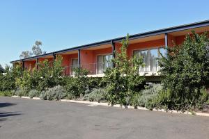 an orange building with plants in front of it at Forbes Victoria Inn in Forbes