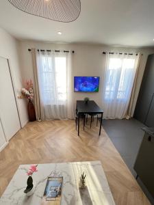 モントルイユにあるSuperbe appartement neuf 2 pièces Vincennes pte de Parisのテーブルとテレビのあるリビングルーム