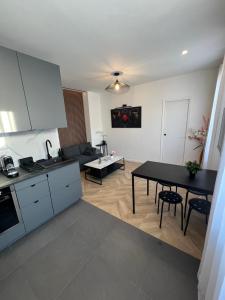 a kitchen and a living room with a table at Superbe appartement neuf 2 pièces Vincennes pte de Paris in Montreuil
