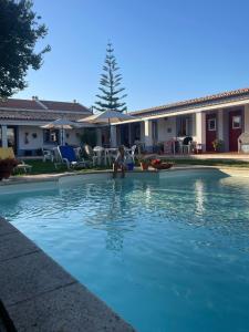 a person sitting in the water in a swimming pool at Monte Novo da Longueira Turismo Rural in Longueira