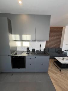a kitchen with white cabinets and a living room at Superbe appartement neuf 2 pièces Vincennes pte de Paris in Montreuil +20 photos