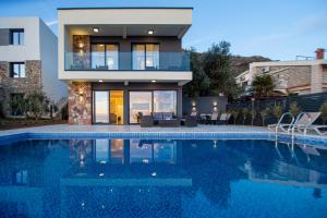 KatunVilla Aurora Azure - Luxury Infinity Pool Resort的一栋房子前面有游泳池