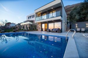 KatunVilla Aurora Azure - Luxury Infinity Pool Resort的一栋前面有游泳池的房子